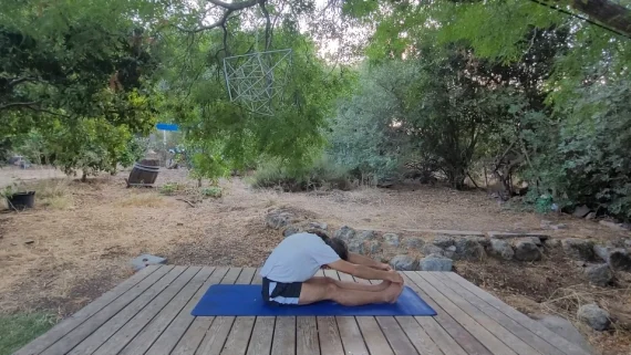 תנוחת פשטימוטהאסנה – גמישות והרפיה גבר בתנוחת פשטימוטהאסנה, יושב על מזרן ומתכופף קדימה כשהראש נוגע בברכיים.