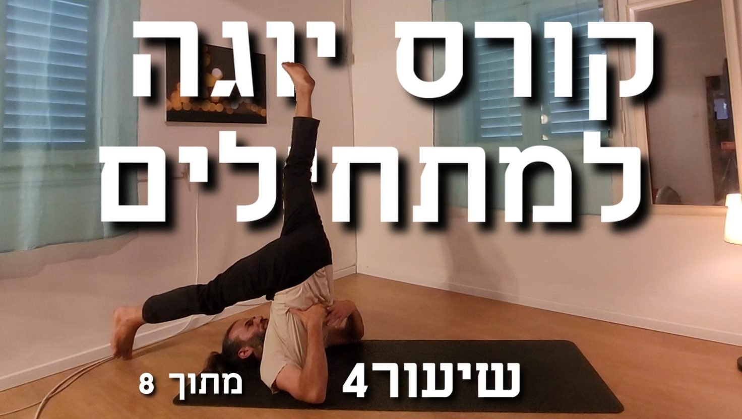 בחור בן 50 - מורה ליוגה עושה תנוחת מחרשה- רגל אחת מאחורי הראש ואחת למעלה. על מרון יוגה בסטודיו יוגה יפה עם וילונות תכלת